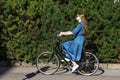 Beautiful young woman and vintage bicycle, summer. Red hair girl riding the old black retro bike outside in the park. Royalty Free Stock Photo