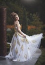 Beautiful woman in an old medieval dress, with a high complex historical hairstyle .