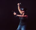 Beautiful young woman with virtual reality headset and joysticks playing video games. Royalty Free Stock Photo