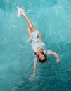 Beautiful young woman with vitiligo depigmentation in white evening dress swimming elegant floating weightless in the pool in