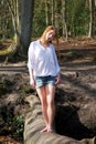 Beautiful young woman walking across a log over creek Royalty Free Stock Photo