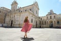 Beautiful young woman walking in the Cathedral Square of the Baroque City of Lecce, Salento, Italy