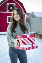 Beautiful young woman walking and delivering gifts during the Christmas season.