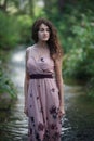 Beautiful young woman walking through the forest river. Royalty Free Stock Photo