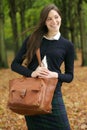 Beautiful young woman walking outdoors with bag on an autumn day Royalty Free Stock Photo