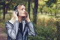 Beautiful young woman walking on a park, listening to music on Royalty Free Stock Photo