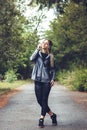 Beautiful young woman walking on a park, listening to music on Royalty Free Stock Photo