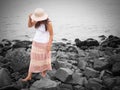 Beautiful young woman walking on the rock beach near the sea. walk away concept. Royalty Free Stock Photo