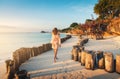 Beautiful young woman is walking on the sandy beach near blue se Royalty Free Stock Photo