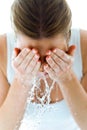 Beautiful young woman washing her face splashing water in a home bathroom. Royalty Free Stock Photo