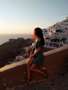 Beautiful young woman watching colorful orange sunset in Oia, Santorini, Greece Royalty Free Stock Photo