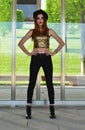Beautiful young woman wearing black hat, gold top and black jeans modeling. Nineteen`s style. Fashion photo shoot. Royalty Free Stock Photo