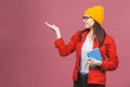 Beautiful young woman wearing casual and eyeglasses standing isolated over pink background, pointing finger, reading a book Royalty Free Stock Photo