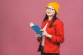 Beautiful young woman wearing casual and eyeglasses standing isolated over pink background, reading a book Royalty Free Stock Photo