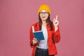 Beautiful young woman wearing casual and eyeglasses standing isolated over pink background, reading a book Royalty Free Stock Photo