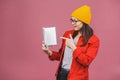 Beautiful young woman wearing casual and eyeglasses standing isolated over pink background, reading a book Royalty Free Stock Photo