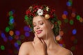 Beautiful young woman wearing Christmas wreath on blurred background Royalty Free Stock Photo