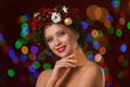 Beautiful young woman wearing Christmas wreath on blurred background Royalty Free Stock Photo