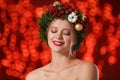 Beautiful young woman wearing Christmas wreath on blurred background Royalty Free Stock Photo