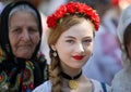 Beautiful young woman wearing a flower headdress and traditional Romanian folk costume during the Romanian Traditional Clothing