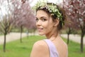 Beautiful young woman wearing flower wreath outdoors on spring day Royalty Free Stock Photo