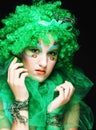 Beautiful young woman wearing green wig with artistic make-up. Royalty Free Stock Photo