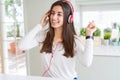 Beautiful young woman wearing headphones listening to music, enjoying and dancing happy Royalty Free Stock Photo