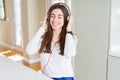 Beautiful young woman wearing headphones listening to music, enjoying and dancing happy Royalty Free Stock Photo