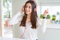 Beautiful young woman wearing headphones listening to music, enjoying and dancing happy Royalty Free Stock Photo