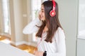 Beautiful young woman wearing headphones listening to music, enjoying and dancing happy Royalty Free Stock Photo