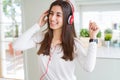 Beautiful young woman wearing headphones listening to music, enjoying and dancing happy Royalty Free Stock Photo