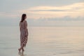 Woman standing in water enjoying sunrise over the sea Royalty Free Stock Photo