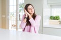 Beautiful young woman wearing pink sweater sleeping tired dreaming and posing with hands together while smiling with closed eyes Royalty Free Stock Photo