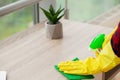 Beautiful young woman wearing protective gloves cleaning the desk in office Royalty Free Stock Photo