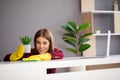 Beautiful young woman wearing protective gloves cleaning the desk in office Royalty Free Stock Photo