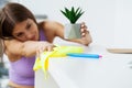 Beautiful young woman wearing protective gloves cleaning the desk in office Royalty Free Stock Photo