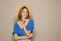 Beautiful young woman wearing straw hat on beige background, space for text. Stylish headdress Royalty Free Stock Photo