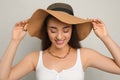 Beautiful young woman wearing straw hat on light grey background. Stylish headdress Royalty Free Stock Photo