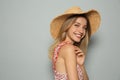 Beautiful young woman wearing straw hat on light grey background, space for text. Stylish headdress Royalty Free Stock Photo