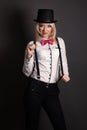 Beautiful young woman wearing tophat, bow-tie and braces against