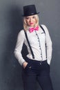 Beautiful young woman wearing tophat, bow-tie and braces against