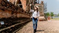 Beautiful young woman wearing white shirt and hat taking photo by mobile in temple ayutthaya thailand, Travel Holiday Relaxation Royalty Free Stock Photo