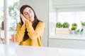 Beautiful young woman wearing yellow sweater sleeping tired dreaming and posing with hands together while smiling with closed eyes Royalty Free Stock Photo