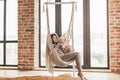 Woman wearing cashmere nightwear relaxing in cabin near fireplace