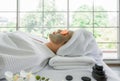 Beautiful young woman in white dress sleep on bed and face peeling mask in spa salon Royalty Free Stock Photo