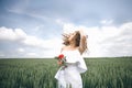 A Beautiful Young Woman In The White Dress Standing In The Field With Rose In Her Hand Royalty Free Stock Photo