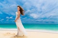 Beautiful young woman in white dress with umbrella on a tropical beach Royalty Free Stock Photo