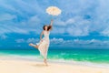 Beautiful young woman in white dress with umbrella on a tropical beach Royalty Free Stock Photo