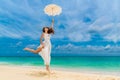 Beautiful young woman in white dress with umbrella on a tropical beach Royalty Free Stock Photo