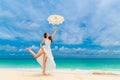 Beautiful young woman in white dress with umbrella on a tropical Royalty Free Stock Photo